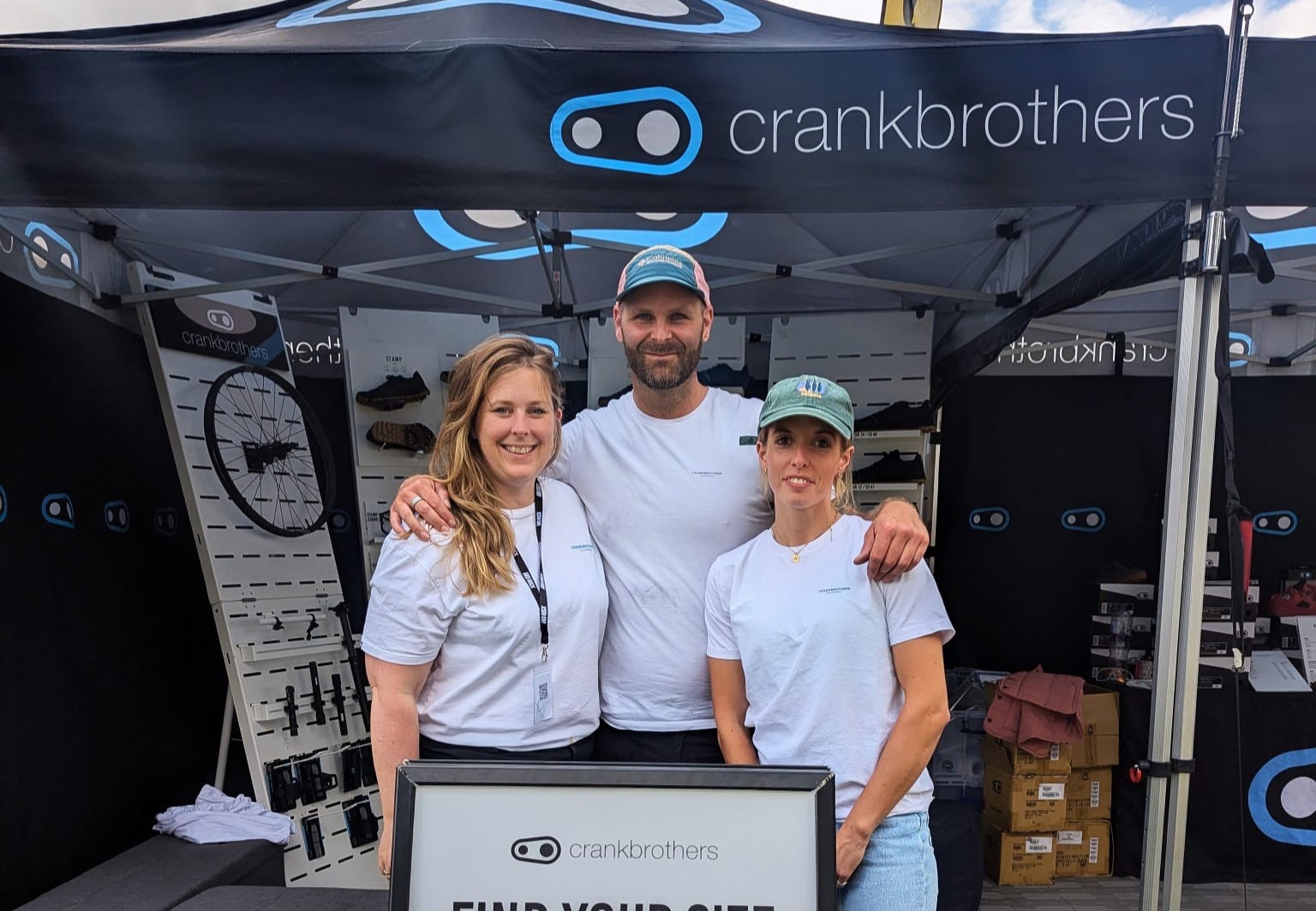 Hannah with her colleagues at a cycling event standing in front of the crankbrothers tent