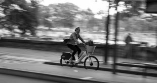 Person riding a Lime bike through the city