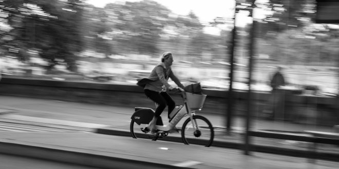 Person riding a Lime bike through the city