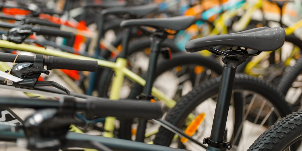 Bikes in a shop lined with a close up of top tubes and saddles
