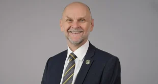 Ashley Wheaton new Chair of Trustees for Cycling UK profile photo. Man in a suit against a grey background